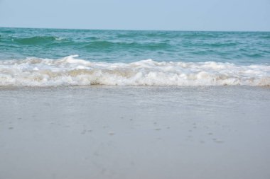 Deniz suyunun sahile vurduğu geniş açı görüntüsü, denizin beyaz süngeri, yaz doğası görüntü konsepti.