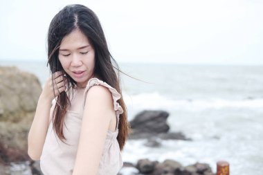 Asyalı bir kadının mutluluğu tahta bir köprüde durup Tatil 'de denize uzanmaktır. Tatilde ve yazın Tayland 'da doğal rüzgar ve denizde gülümsüyor.