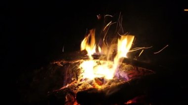 Ateş gece yanar. Alevler ve kıvılcımlar gecenin içine uçar.