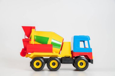Beyaz arka planda çok renkli plastik çocuk arabaları. Beton kamyon..