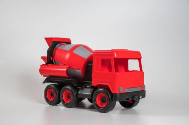 Beyaz arka planda çok renkli plastik çocuk arabaları. Kırmızı beton kamyon.