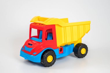 Beyaz arka planda çok renkli plastik çocuk arabaları..
