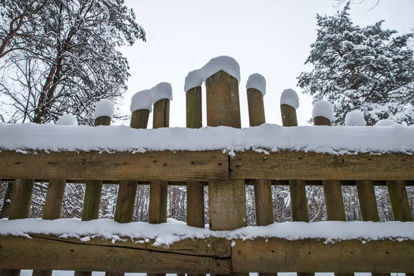 Деревянный забор под снежными шапками. — стоковое фото