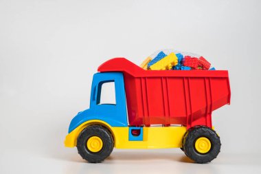 Beyaz arka planda çok renkli plastik çocuk arabaları..