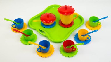 Beyaz arka planda çok renkli plastik sofra takımı..