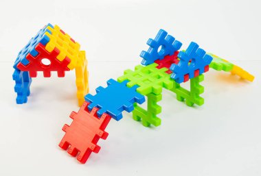 Beyaz arka planda plastik çocuk inşaatçısı. Tasarımcının çok renkli ayrıntılarından figürler.