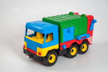 Beyaz arka planda çok renkli plastik çocuk arabaları..