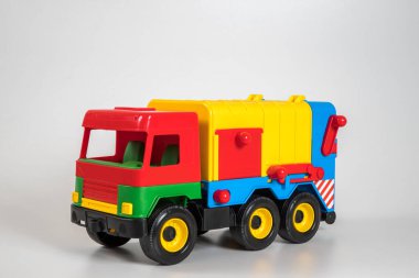 Beyaz arka planda çok renkli plastik çocuk arabaları..