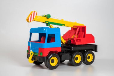 Beyaz arka planda çok renkli plastik çocuk arabaları..