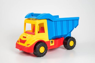 Beyaz arka planda çok renkli plastik çocuk arabaları..