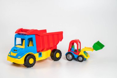 Beyaz arka planda çok renkli plastik çocuk arabaları..