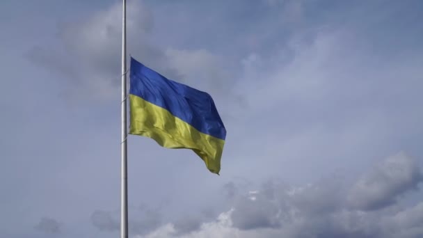Die gelb-blaue Nationalflagge der Ukraine flattert vor einem wolkenverhangenen blauen Himmel. — Stockvideo