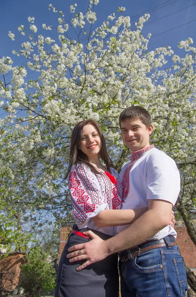 Young Loving Couple Man Woman White Embroidered Shirts Flowering Tree — 스톡 사진