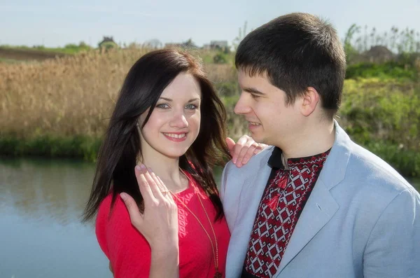 这个女孩展示了一枚由一个男人戴在她手上的结婚戒指 一对幸福的情侣 在大自然中 在一条河和一片草地的背景下 坠入爱河 — 图库照片