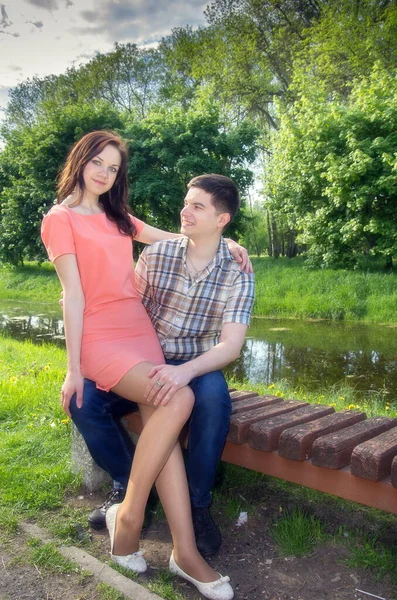 一个穿着粉红衣服的女孩坐在公园长椅上一个男人的腿上 一对美丽的恋人的爱情故事 — 图库照片