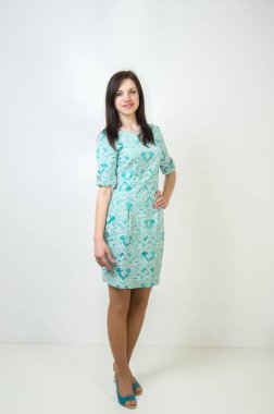 Beyaz arka planda yeşil elbiseli, ince bir kadın..