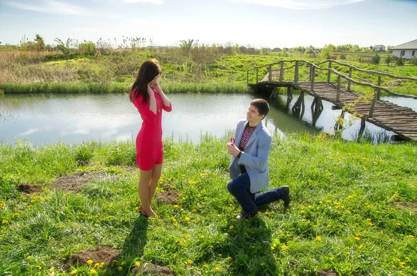 草原の男は膝の上にいて女の子に指輪を与え結婚を申し出た — ストック写真