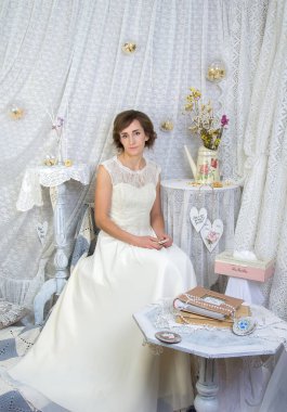 Beyaz, uzun, zarif bir elbise giymiş, Provence tarzında pastel bir iç mekan giymiş bir kız..