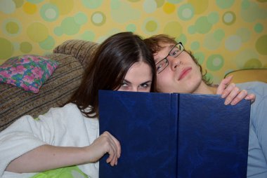 Öğrenci çift kanepede ders çalışacak ve sınavlara hazırlanacak..