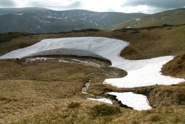 Bahar karları dağlarda eriyor, güneş ışınları altında karardı..