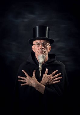 Siyah şapkalı ve siyah cüppeli gizemli bir erkek sihirbazın portresi..