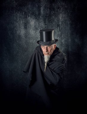 Siyah şapkalı ve siyah cüppeli gizemli bir erkek sihirbazın portresi..