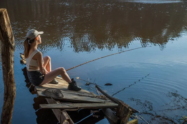 Una Chica Con Una Caña Pescar Muelle Madera Está Pescando — Foto de Stock