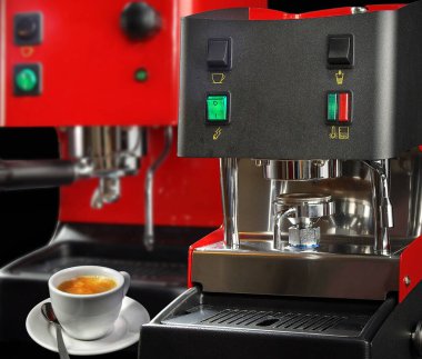 Siyah arka planda kırmızı kahve makinesi. Seçmeli odak noktası. Arka plan bulanık. Köpüklü beyaz bir fincan aromatik kahve..