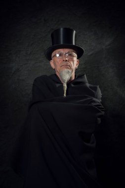 Siyah şapkalı ve siyah cüppeli gizemli bir erkek sihirbazın portresi..