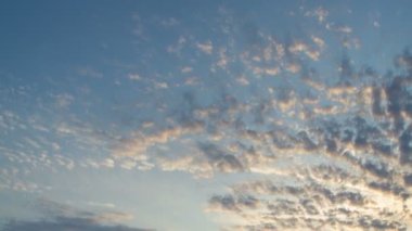 The clouds in the sky darken as night falls.