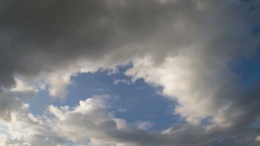 Background clouds float across the blue sky. For a screensaver with a free middle of the frame for the inscription.