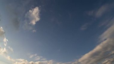 Background clouds float across the blue sky. For a screensaver with a free middle of the frame for the inscription.