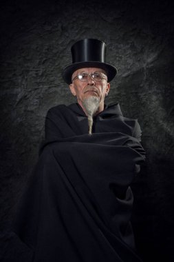 Siyah şapkalı ve siyah cüppeli gizemli bir erkek sihirbazın portresi..