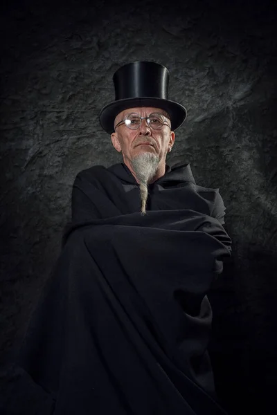 黒の高い帽子と黒の衣を着た謎の男性魔術師の肖像 — ストック写真