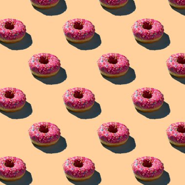 Pembe donutların pürüzsüz desenleri, gölgeli sıcak bir arka planda.