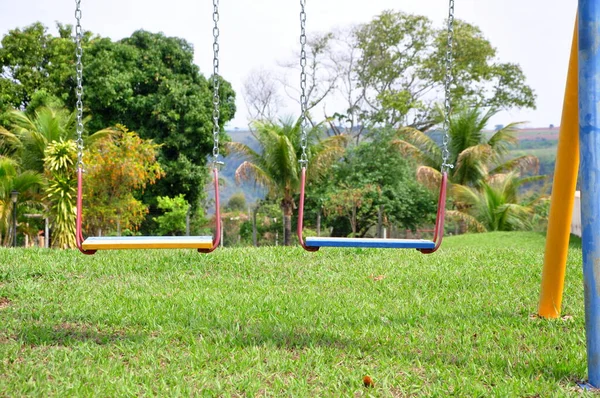 子供のおもちゃ 木製の子供のスイングとサポートと鉄の固定と草のベース上のブラジル ブラジル 南米の観光農場の青と黄色の色のチェーン フォトズーム — ストック写真