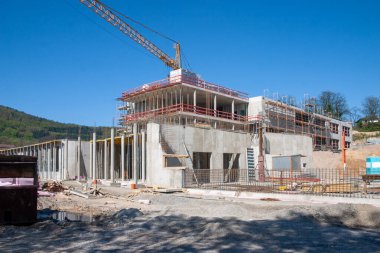 İnşaat alanında beton ve inşaat vinciyle güçlendirilmiş bir binanın ereksiyonu sırasında