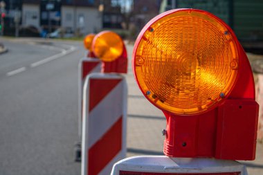 Yol inşaatı sahasının güvenliğine uyarı lambası konmuş sokak barikatı, bulanık alan geçmişi.