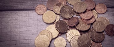 Bir ahşap yüzey üzerinde kısmen çok kullanılmış Eurocent sikkeleri koleksiyonu