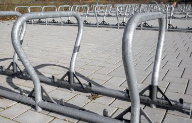 Geniş bir halka açık otoparkta parantez şeklinde bir grup modern bisikletin yakın çekimleri
