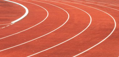 Spor merkezindeki kıvrımlı kırmızı atletizm pistini kapatın.