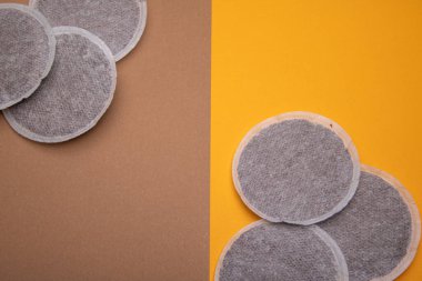 Turuncu ve kahverengi kartondaki kahve yastıklarının üst görüntüsü. Düz Yat bileşimi