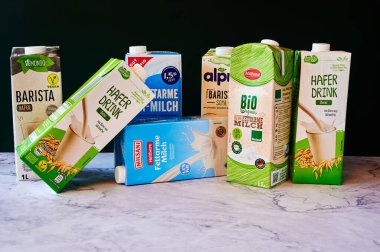 Berlin, Almanya - 25 Kasım 2021: İnek sütü, soya ve yulafından yapılan farklı süt paketleri.