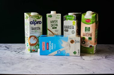Berlin, Almanya - 25 Kasım 2021: İnek sütü, soya ve yulafından yapılan farklı süt paketleri.