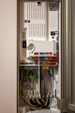 Görünür kabloları olan modern bir ısıtma sisteminin kontrol kutusunu aç. Odak noktası fotoğrafın ortasındaki üst terminal blokları..