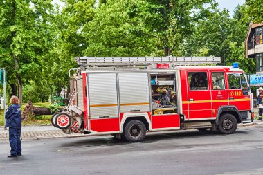 Berlin, Almanya - 12 Haziran 2019: Şiddetli bir fırtınadan sonra Almanya 'nın Berlin kentinde ana caddede bulunan köklerinden sökülmüş bir ağaç. Kurtarma ekipleri kaza mahallinde çalışıyor..