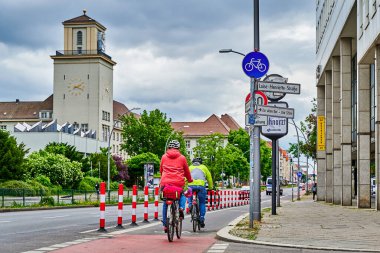 Berlin, Almanya - 29 Mayıs 2022: Yol güvenliğini artırmak için ana yolda özel bir bisiklet şeridinde bisikletçiler.