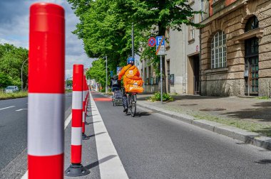 Berlin, Almanya - 29 Mayıs 2022: Yol güvenliğini artırmak için ana yolda özel bir bisiklet şeridinde bisikletçiler.