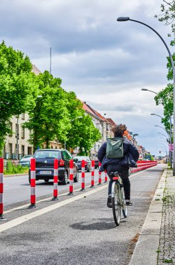Berlin, Almanya - 29 Mayıs 2022: Yol güvenliğini artırmak için ana yolda özel bir bisiklet şeridinde bisikletçi.