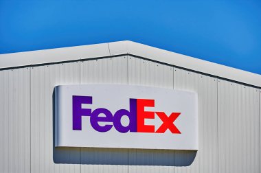Grossbeeren, Almanya - 21 Haziran 2022: Küresel lojistik şirketinin sevkiyat merkezi yakınlarındaki bir FedEx logosuna bakın.